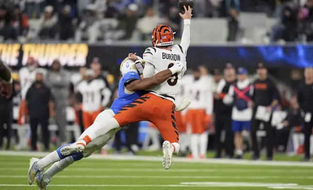 Cincinnati Bengals quarterback Joe Burrow (9) throws as he is tackled by Los Angeles Chargers linebacker Daiyan Henley (0) during the second half of an NFL football game Sunday, Nov. 17, 2024, in Inglewood, Calif. (AP Photo/Gregory Bull)