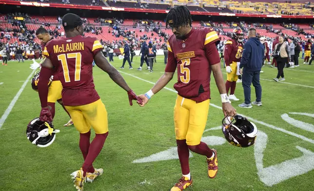 Washington Commanders quarterback Jayden Daniels (5) and wide receiver Terry McLaurin (17) walk across the field after the 34-26 loss to the Dallas Cowboys of an NFL football game, Sunday, Nov. 24, 2024, in Landover, Md. (AP Photo/Nick Wass)