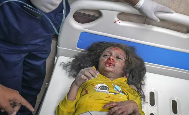 A girl injured during an overnight Israeli army strike is assisted upon her arrival at the hospital in Deir al-Balah, Gaza Strip, Sunday Nov. 24, 2024. (AP Photo/Abdel Kareem Hana)