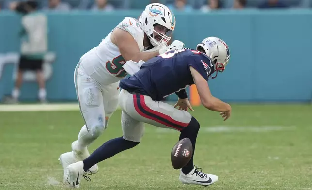 New England Patriots quarterback Drake Maye (10) fumbles the ball under pressure from Miami Dolphins defensive tackle Zach Sieler (92) during the second half of an NFL football game, Sunday, Nov. 24, 2024, in Miami Gardens, Fla. (AP Photo/Lynne Sladky)