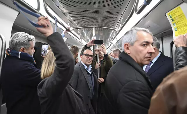 Reporters and officials use the metro during a media day ahead of its Nov. 30 official opening, in Thessaloniki, northern Greece, Friday, Nov. 22, 2024 – part of the city's long-delayed subway system showcasing archaeological finds from decades of construction. (AP Photo/Giannis Papanikos)