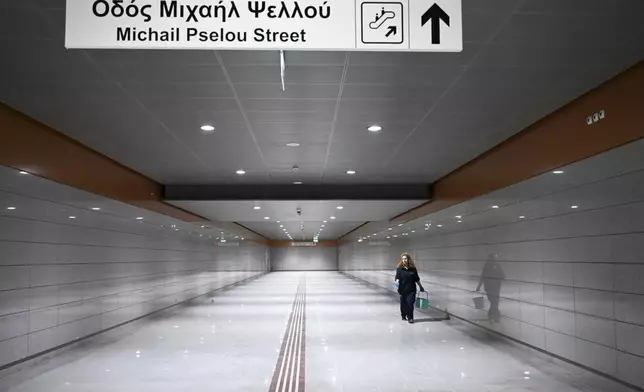 A member of the cleaning staff walks through the newly built Nea Elvetia metro station ahead of its Nov. 30 official opening, in Thessaloniki, northern Greece, Friday, Nov. 22, 2024 – part of the city's long-delayed subway system showcasing archaeological finds from decades of construction. (AP Photo/Giannis Papanikos)