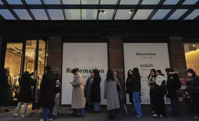 People wait in line for a sample sale in the Meatpacking District of Manhattan, Friday, Nov. 22, 2024, in New York. (AP Photo/Julia Demaree Nikhinson)