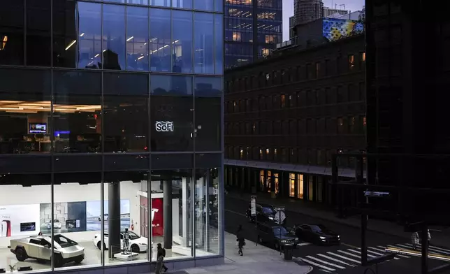 People walk past a Tesla store in the Meatpacking District of Manhattan, Friday, Nov. 22, 2024, in New York. (AP Photo/Julia Demaree Nikhinson)