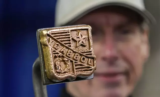 John Jobbagy shows his stamp on a cut of beef during an interview at J.T. Jobbagy Inc. in the Meatpacking District of Manhattan, Tuesday, Nov. 19, 2024, in New York. (AP Photo/Julia Demaree Nikhinson)