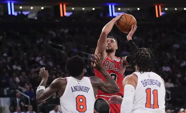 Chicago Bulls' Zach LaVine, center, shoots over New York Knicks' OG Anunoby (8), left, and Jalen Brunson (11) during the second half of an NBA basketball game, Wednesday, Nov. 13, 2024, in New York. The Bulls defeated the Knicks 124-123. (AP Photo/Seth Wenig)