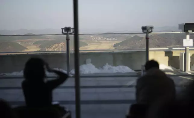 Visitors sit at newly opened Starbucks store as North Korea's Kaephung county is seen on background at the observatory of the Aegibong Peace Ecopark in Gimpo, South Korea, Friday, Nov. 29, 2024. (AP Photo/Lee Jin-man)