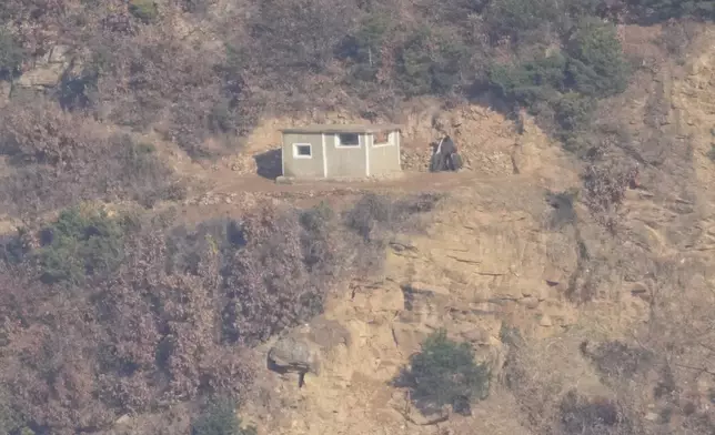 Two North Korean soldiers sit near a North Korean military guard post, seen from Gimpo, South Korea, Friday, Nov. 29, 2024. (AP Photo/Lee Jin-man)