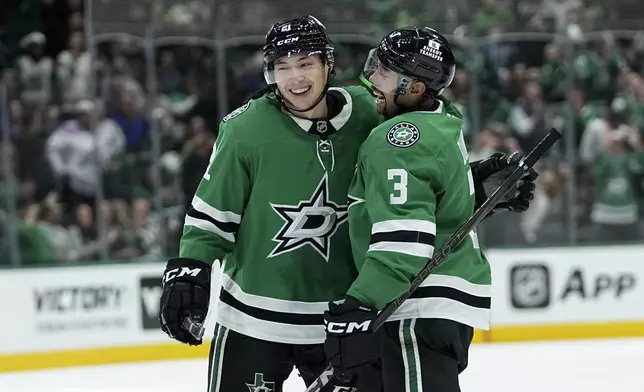 Dallas Stars left wing Jason Robertson (21) and Mathew Dumba (3) celebrate after Robertson scored against the San Jose Sharks in the first period of an NHL hockey game in Dallas, Wednesday, Nov. 20, 2024. (AP Photo/Tony Gutierrez)