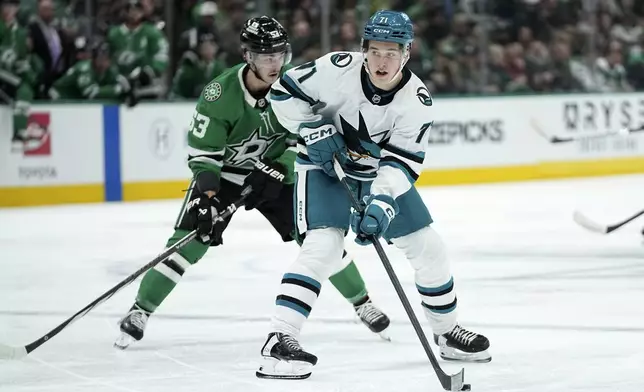 San Jose Sharks center Macklin Celebrini (71) controls the puck in front of Dallas Stars center Wyatt Johnston in the second period of an NHL hockey game in Dallas, Wednesday, Nov. 20, 2024. (AP Photo/Tony Gutierrez)