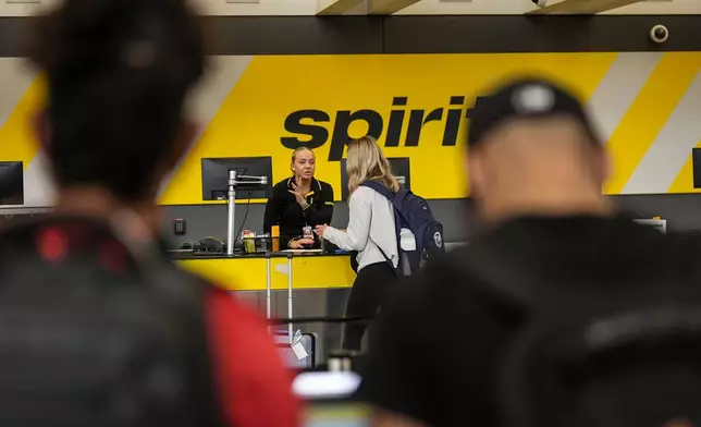 FILE - A traveler speaks with a Spirit Airlines agent at Hartsfield-Jackson Atlanta International Airport ahead of Memorial Day, on May 24, 2024, in Atlanta. (AP Photo/Mike Stewart, File)