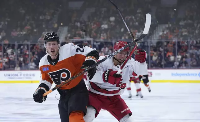 Carolina Hurricanes' Jack Drury, right, breaks his stick battling against Philadelphia Flyers' Nick Seeler during the third period of an NHL hockey game, Wednesday, Nov. 20, 2024, in Philadelphia. (AP Photo/Matt Slocum)