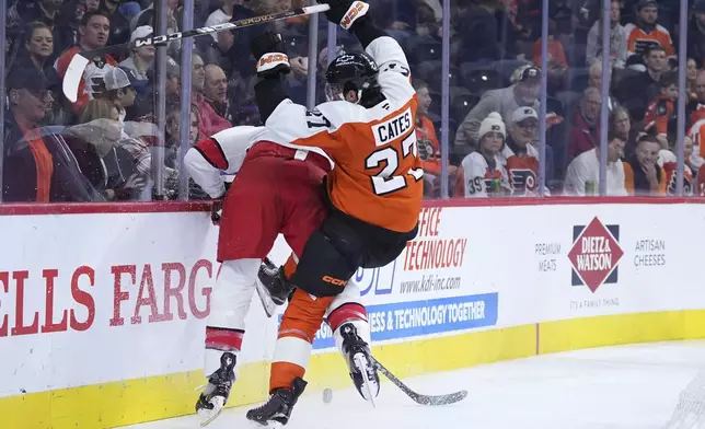 Philadelphia Flyers' Noah Cates, right, and Carolina Hurricanes' Brent Burns collide during the second period of an NHL hockey game, Wednesday, Nov. 20, 2024, in Philadelphia. (AP Photo/Matt Slocum)