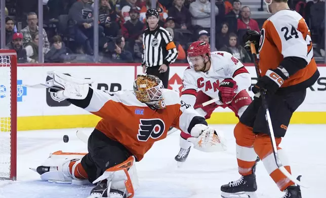 Carolina Hurricanes' Jack Roslovic, center, scores a goal against Philadelphia Flyers' Ivan Fedotov during the third period of an NHL hockey game, Wednesday, Nov. 20, 2024, in Philadelphia. (AP Photo/Matt Slocum)