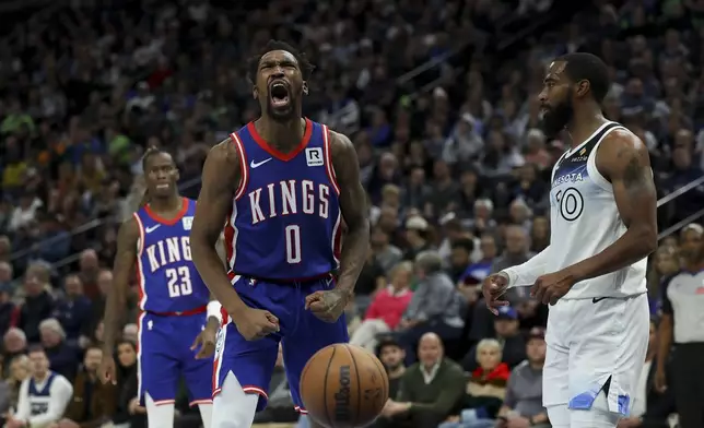 Sacramento Kings guard Malik Monk (0) reacts after scoring and drawing a foul while Minnesota Timberwolves guard Mike Conley (10) looks up the court during the first half of an NBA basketball game, Wednesday, Nov. 27, 2024, in Minneapolis. (AP Photo/Ellen Schmidt)