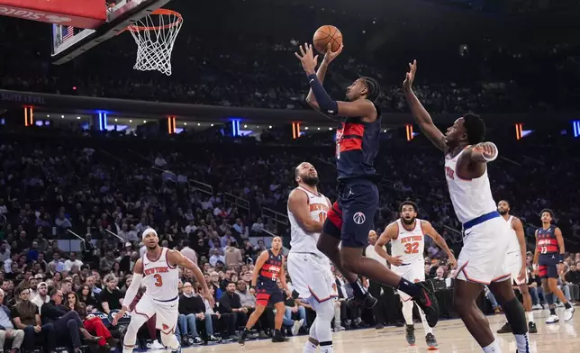 Washington Wizards' Alexandre Sarr, top, puts up a shot during the first half of an NBA basketball game against the New York Knicks, Monday, Nov. 18, 2024, in New York. (AP Photo/Seth Wenig)