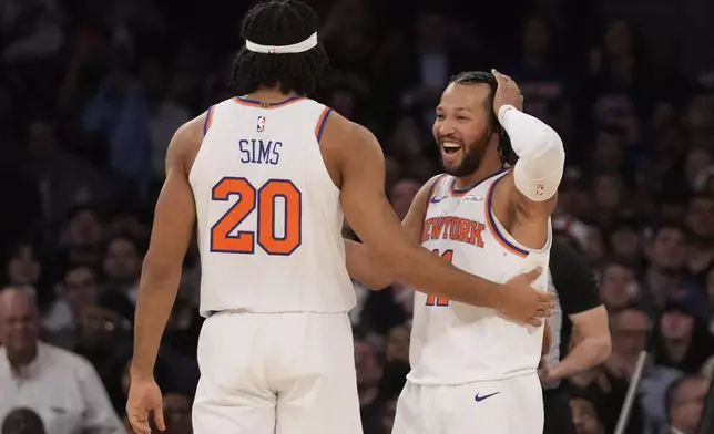 New York Knicks' Jalen Brunson, right, celebrates with teammate Jericho Sims after Sims dunked the ball during the first half of an NBA basketball game against the Washington Wizards, Monday, Nov. 18, 2024, in New York. (AP Photo/Seth Wenig)