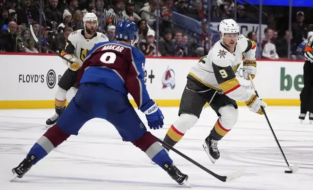 Vegas Golden Knights center Jack Eichel, right, drives down the ice with the puck as Colorado Avalanche defenseman Cale Makar drops back to cover in the second period of an NHL hockey game Wednesday, Nov. 27, 2024, in Denver. (AP Photo/David Zalubowski)