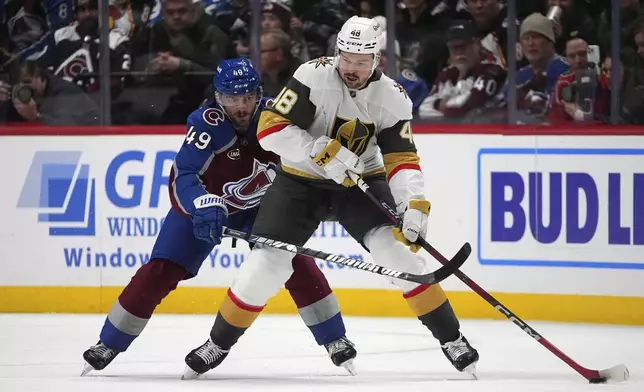 Vegas Golden Knights center Tomas Hertl, front, passes the puck as Colorado Avalanche defenseman Samuel Girard covers in the first period of an NHL hockey game Wednesday, Nov. 27, 2024, in Denver. (AP Photo/David Zalubowski)