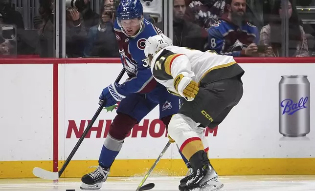 Colorado Avalanche center Casey Mittelstadt, back, looks to pass the puck as Vegas Golden Knights center William Karlsson defends in the second period of an NHL hockey game Wednesday, Nov. 27, 2024, in Denver. (AP Photo/David Zalubowski)