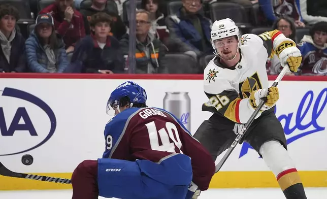 Vegas Golden Knights right wing Alexander Holtz, back, shoots the puck past Colorado Avalanche defenseman Samuel Girard in the second period of an NHL hockey game, Wednesday, Nov. 27, 2024, in Denver. (AP Photo/David Zalubowski)