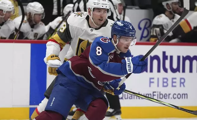 Colorado Avalanche defenseman Cale Makar, front, pursues the puck with Vegas Golden Knights center Ivan Barbashev in the second period of an NHL hockey game, Wednesday, Nov. 27, 2024, in Denver. (AP Photo/David Zalubowski)