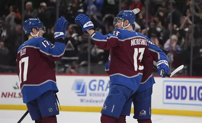 Colorado Avalanche center Parker Kelly, left, congratulates right wing Valeri Nichushkin after he scored the winning goal during the shootout of an NHL hockey game against the Vegas Golden Knights Wednesday, Nov. 27, 2024, in Denver. (AP Photo/David Zalubowski)