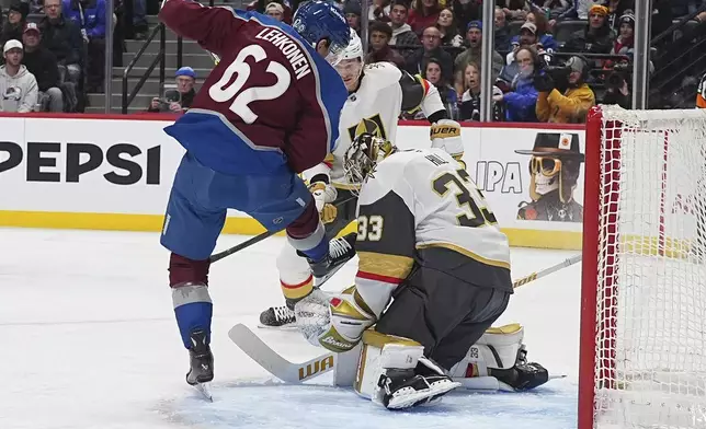 Vegas Golden Knights goaltender Adin Hill, right, makes a save of a redirected shot off the stick of Colorado Avalanche left wing Artturi Lehkonen in the first period of an NHL hockey game Wednesday, Nov. 27, 2024, in Denver. (AP Photo/David Zalubowski)