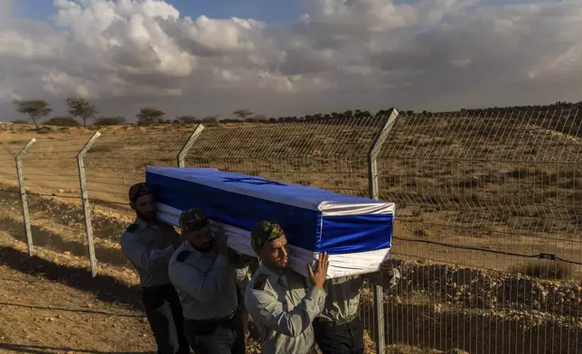 Israeli soldiers carry the coffin of captain Yogev Pazi, who was killed in Gaza, during his funeral at the cemetery of Giv'ot Bar, southern Israel, Monday, Nov. 18, 2024. (AP Photo/Francisco Seco)