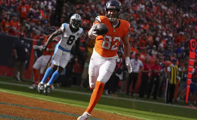 Denver Broncos tight end Adam Trautman (82) catches a pass for a touchdown against the Carolina Panthers during the first half during an NFL football game Sunday, Oct. 27, 2024, in Denver. (AP Photo/Bart Young)