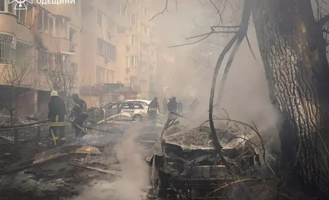 In this photo provided by the Ukrainian Emergency Service, emergency services personnel work to extinguish a fire following a Russian rocket attack in Odesa, Ukraine, Monday, Nov. 18, 2024. (Ukrainian Emergency Service via AP)