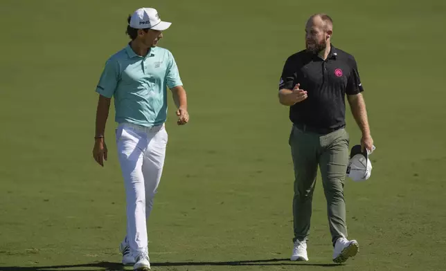 Joaquin Niemann of Chile, left, and Tyrell Hatton of England walk towards the 1st green during the second round of World Tour Golf Championship in Dubai, United Arab Emirates, Saturday, Nov. 16, 2024. (AP Photo/Altaf Qadri)