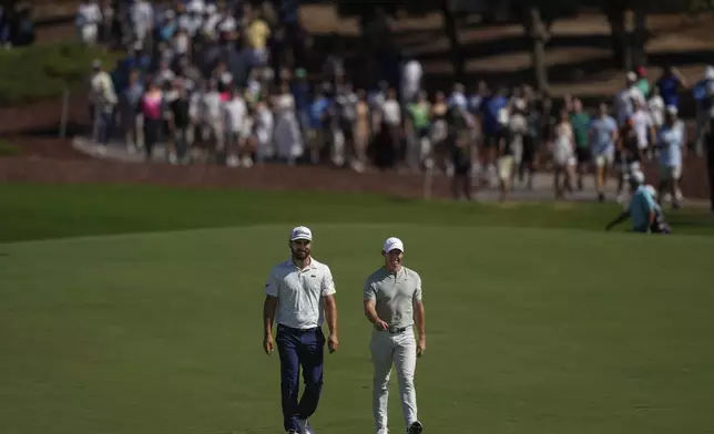 Antoine Rozner of France, left, and Rory McIlroy of Northern Ireland walk towards the 1st green during the second round of World Tour Golf Championship in Dubai, United Arab Emirates, Saturday, Nov. 16, 2024. (AP Photo/Altaf Qadri)