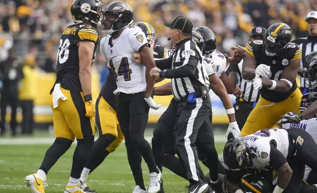 Pittsburgh Steelers tight end Pat Freiermuth, left, and Baltimore Ravens cornerback Marlon Humphrey argue as back judge Greg Wilson (119) tries to intervene during the first half of an NFL football game, Sunday, Nov. 17, 2024, in Pittsburgh. (AP Photo/Gene J. Puskar)