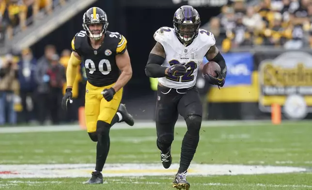 Baltimore Ravens running back Derrick Henry (22) runs with the ball in front of Pittsburgh Steelers linebacker T.J. Watt (90) during the first half of an NFL football game, Sunday, Nov. 17, 2024, in Pittsburgh. (AP Photo/Matt Freed)