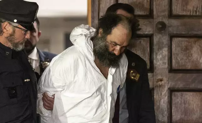 Ramon Rivera, a suspect arrested after multiple people were stabbed early Monday, is escorted out by NYPD officers at the NYPD 10th Precinct in New York, Monday, Nov. 18, 2024. (AP Photo/Yuki Iwamura)