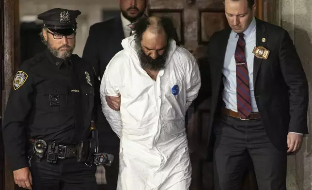 Ramon Rivera, a suspect arrested after multiple people were stabbed early Monday, is escorted out by NYPD officers at the NYPD 10th Precinct in New York, Monday, Nov. 18, 2024. (AP Photo/Yuki Iwamura)