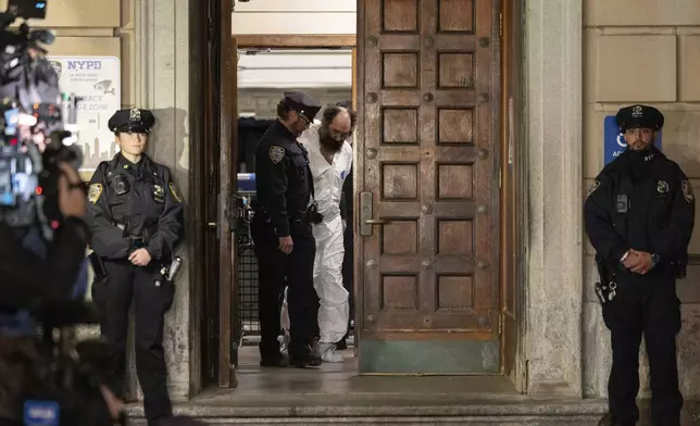 Ramon Rivera, a suspect arrested after multiple people were stabbed early Monday, is escorted out by NYPD officers at the NYPD 10th Precinct in New York, Monday, Nov. 18, 2024. (AP Photo/Yuki Iwamura)