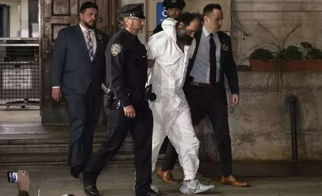 Ramon Rivera, a suspect arrested after multiple people were stabbed early Monday, is escorted out by NYPD officers at the NYPD 10th Precinct in New York, Monday, Nov. 18, 2024. (AP Photo/Yuki Iwamura)