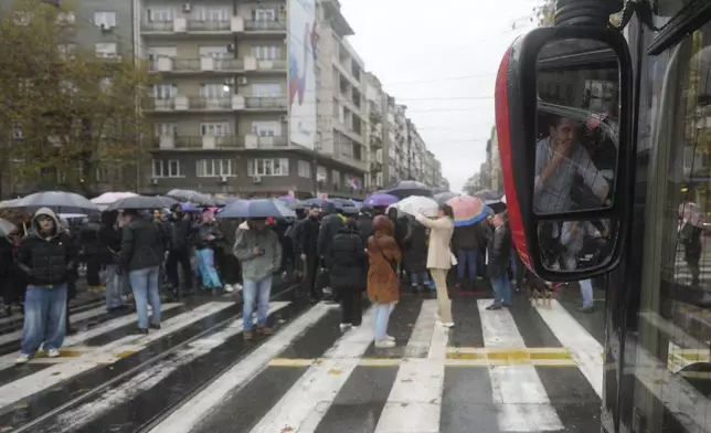 A bus driver watches stopped traffic to commemorate the 15 victims of a railway roof collapse two weeks ago, as people demand accountability for the tragedy, in Belgrade, Serbia, Friday, Nov. 22, 2024. (AP Photo/Darko Vojinovic)