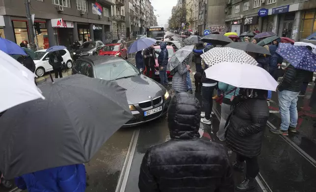 People stopping traffic and standing in silence to commemorate the 15 victims of a railway roof collapse two weeks ago, demand accountability for the tragedy, in Belgrade, Serbia, Friday, Nov. 22, 2024. (AP Photo/Darko Vojinovic)