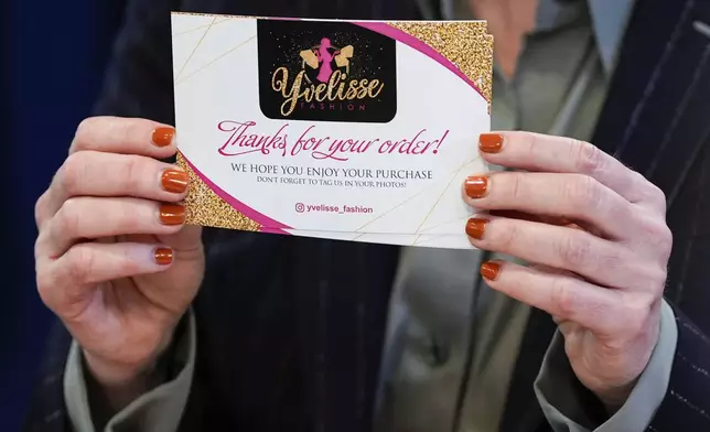 Queens District Attorney Melinda Katz shows a business card during a news conference on an international stolen merchandise ring, Tuesday, Nov. 26, 2024, in the Queens borough of New York. (AP Photo/Julia Demaree Nikhinson)