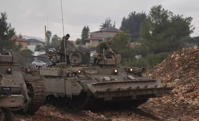 Israeli soldiers stand atop army armoured vehicles outside the agricultural settlement of Avivim, next to the Lebanese border in upper Galilee, Israel, Thursday Nov 28, 2024. (AP Photo/Ohad Zwigenberg)