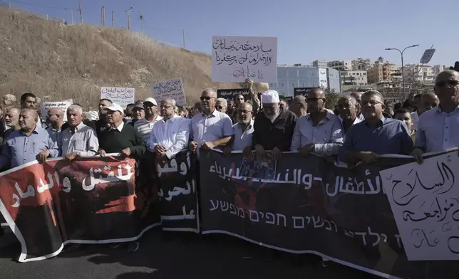 Lawmaker Ahmad Tibi, fifth from left, joins Palestinian citizens of Israel in a march against Israel's military operations in the Gaza Strip, in Umm al-Fahm, Israel, Friday, Nov. 15, 2024. (AP Photo/Mahmoud Illean)