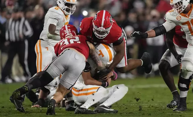 Tennessee quarterback Nico Iamaleava (8) is sacked by Georgia defensive lineman Xzavier McLeod (94) and linebacker Chaz Chambliss (32) during the first half of an NCAA college football game, Saturday, Nov. 16, 2024, in Athens, Ga. (AP Photo/John Bazemore)