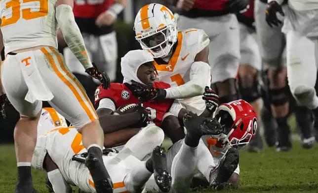 Georgia wide receiver Nitro Tuggle (2) loses his helmet as he is tackled by Tennessee defensive back Andre Turrentine (2) during the second half of an NCAA college football game, Saturday, Nov. 16, 2024, in Athens, Ga. (AP Photo/John Bazemore)