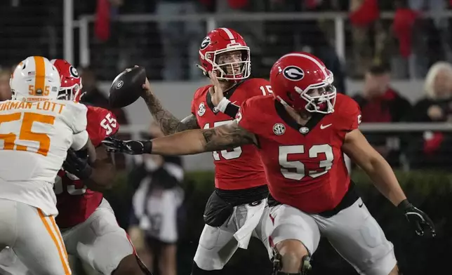 Georgia quarterback Carson Beck (15) throws from behind offensive lineman Dylan Fairchild (53) during the first half of an NCAA college football game against Tennessee , Saturday, Nov. 16, 2024, in Athens, Ga. (AP Photo/John Bazemore)