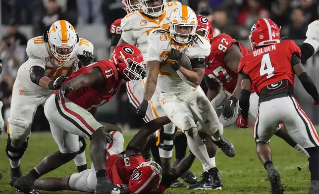 Tennessee running back Peyton Lewis (27) tries to brel free from Georgia's CJ Allen (3) and Jalon Walker (11) during the first half of an NCAA college football game, Saturday, Nov. 16, 2024, in Athens, Ga. (AP Photo/John Bazemore)