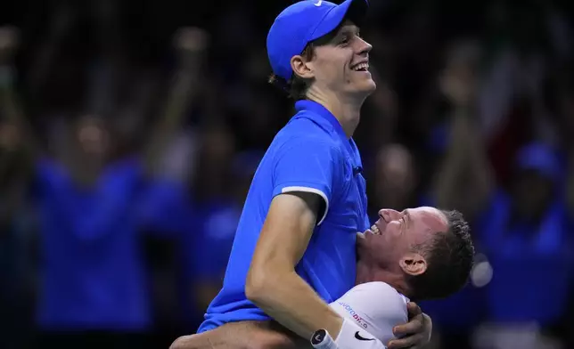 Italy's Jannik Sinner celebrates with team captain Filippo Volandri as he defeats Netherlands' Tallon Griekspoor during the Davis Cup final tennis match between Netherlands and Italy at the Martin Carpena Sports Hall in Malaga, southern Spain, Sunday, Nov. 24, 2024. (AP Photo/Manu Fernandez)