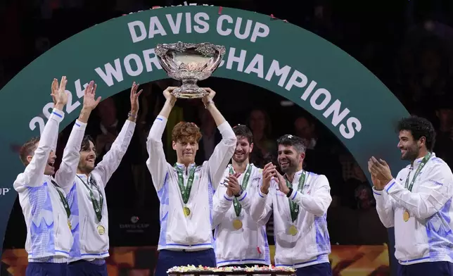 Italy's Jannik Sinner, center, holds the Davis Cup trophy by teammates after the final between Netherlands and Italy at the Martin Carpena Sports Hall in Malaga, southern Spain, as Italy wins its second consecutive Davis Cup title, Sunday, Nov. 24, 2024. (AP Photo/Manu Fernandez)